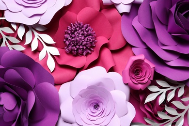 Different beautiful flowers and branches made of paper as background, top view