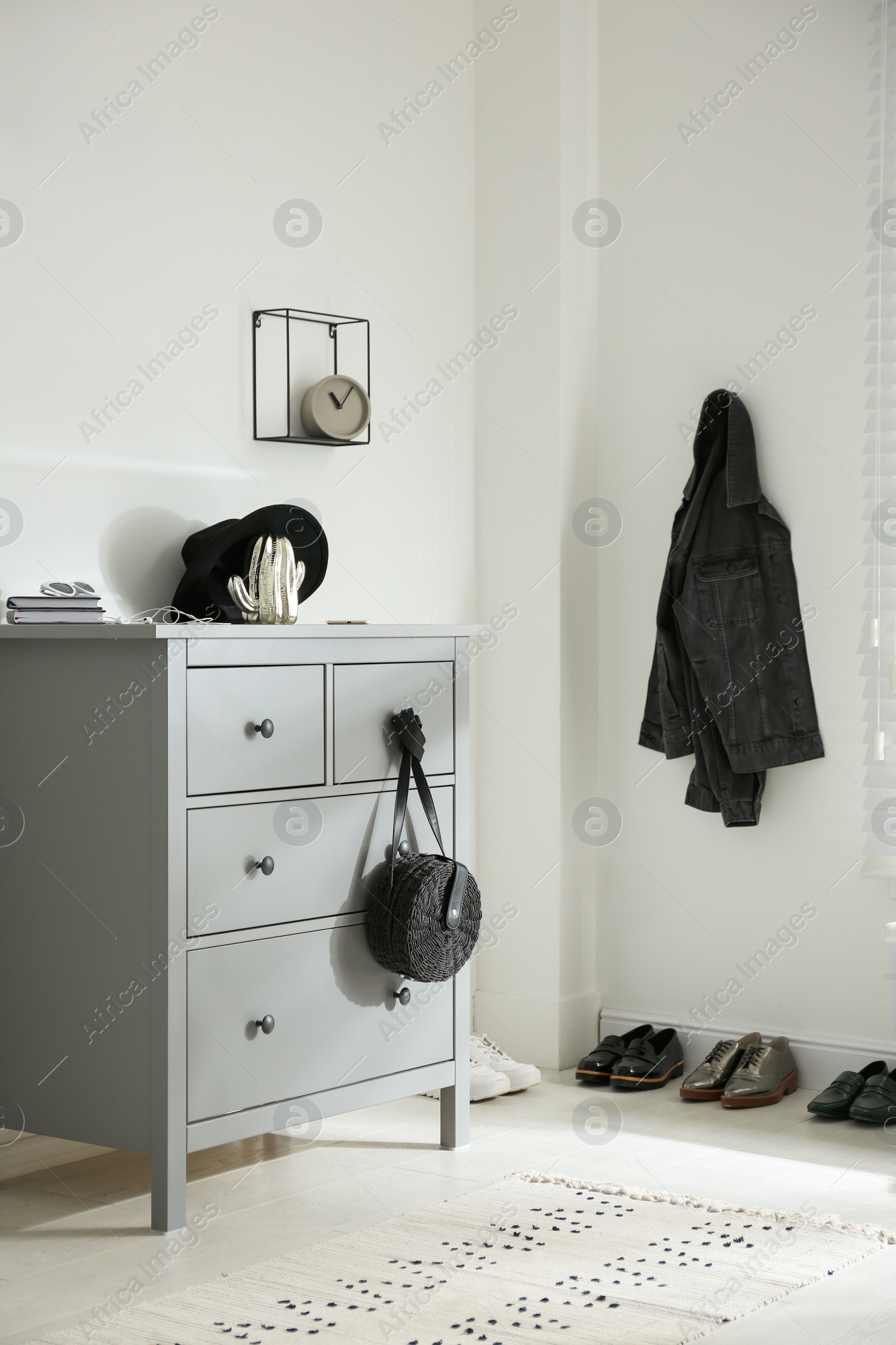 Photo of Grey chest of drawers in stylish room. Interior design