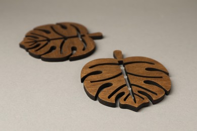 Photo of Leaf shaped wooden cup coasters on light grey background