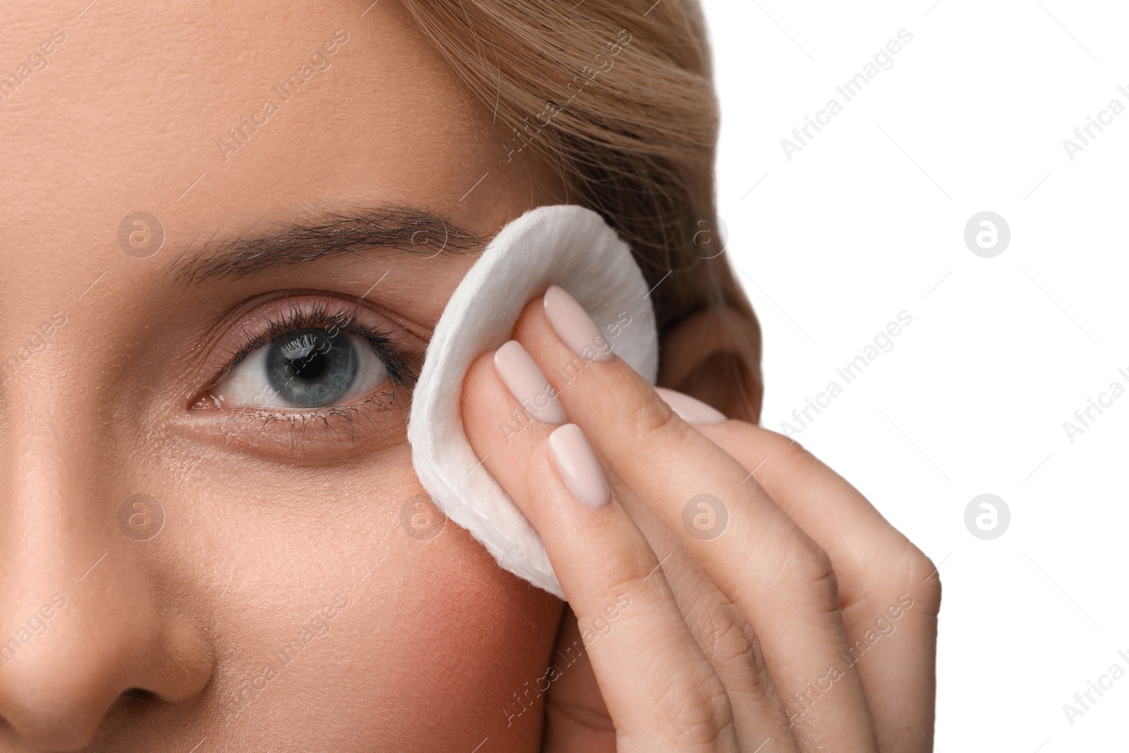 Photo of Woman removing makeup with cotton pad on white background, closeup