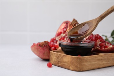 Photo of Tasty pomegranate sauce and fruits on light table, closeup. Space for text