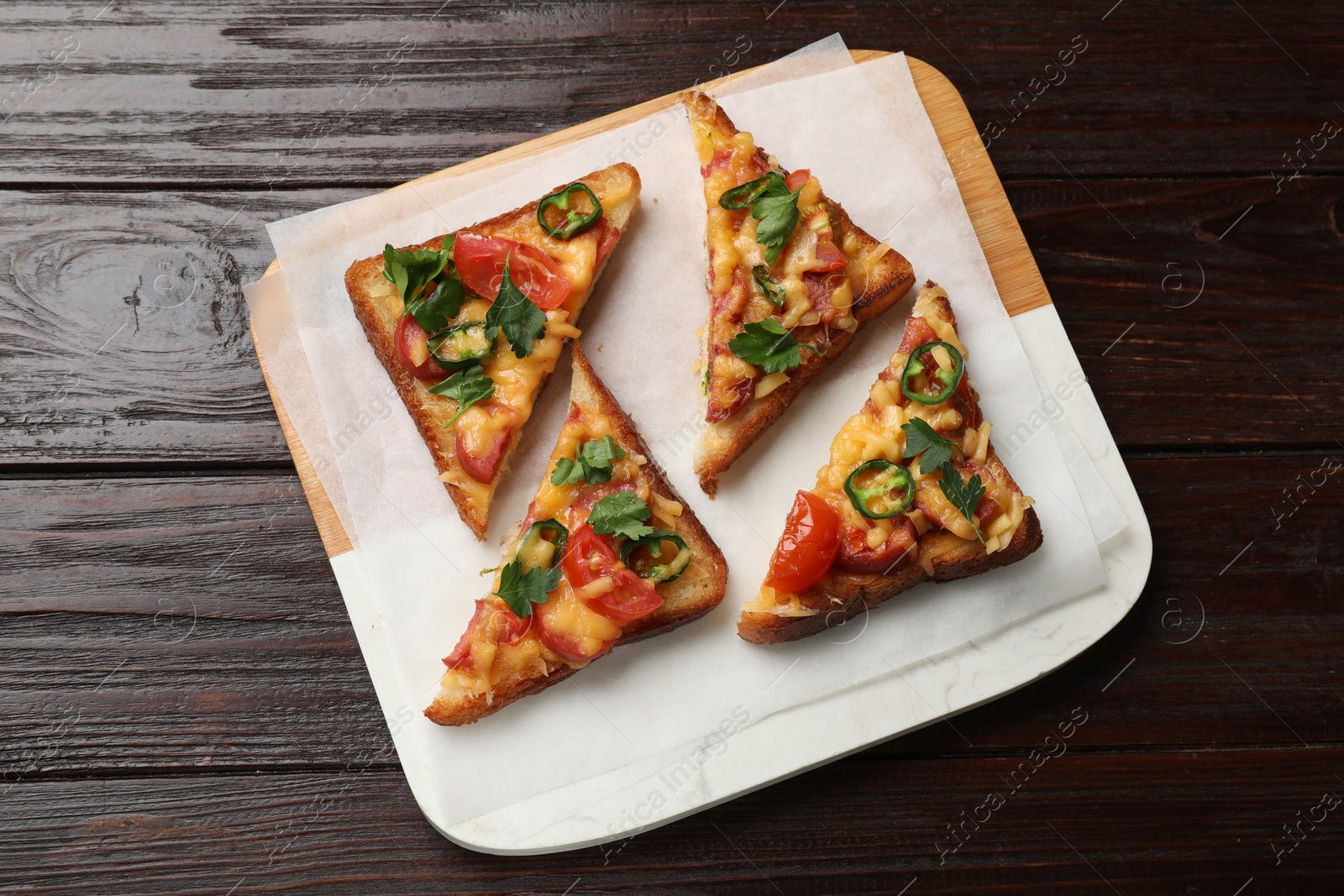 Photo of Tasty pizza toasts served on wooden table, top view