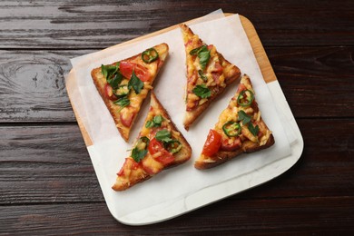 Tasty pizza toasts served on wooden table, top view