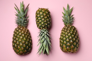 Photo of Fresh whole pineapples on pink background, top view