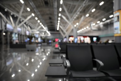 Photo of Blurred view of waiting area with seats in airport terminal