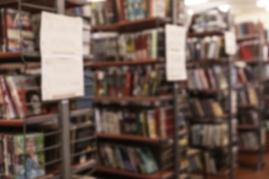 Photo of Blurred view of shelving units with books in library