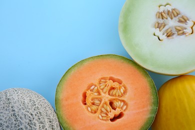 Photo of Different tasty ripe melons on turquoise background, flat lay. Space for text