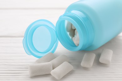 Photo of Jar with chewing gums on white wooden table, closeup