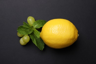 Photo of Fresh ripe lemon, grapes and mint on black background, flat lay