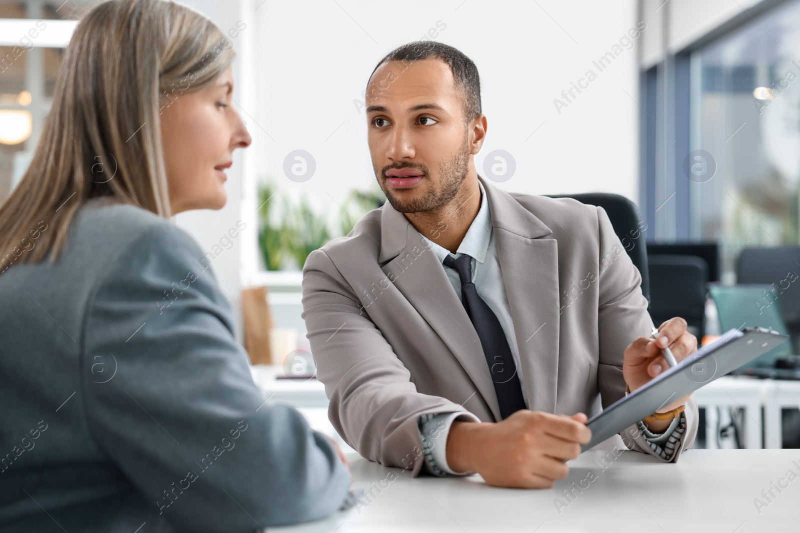 Photo of Lawyers with clipboard working together at table in office