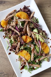 Photo of Delicious salad with beef tongue, orange and onion on wooden table, top view