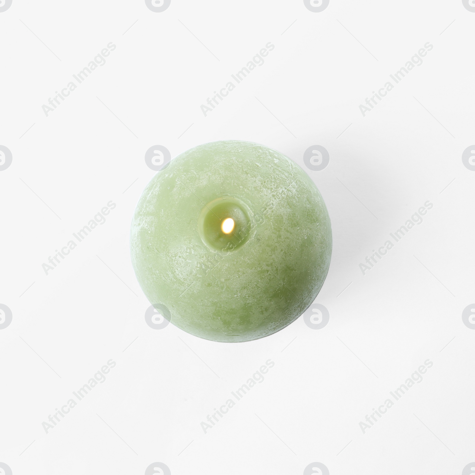 Photo of Burning green candle isolated on white, top view