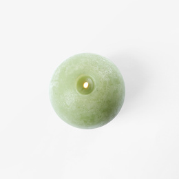 Burning green candle isolated on white, top view