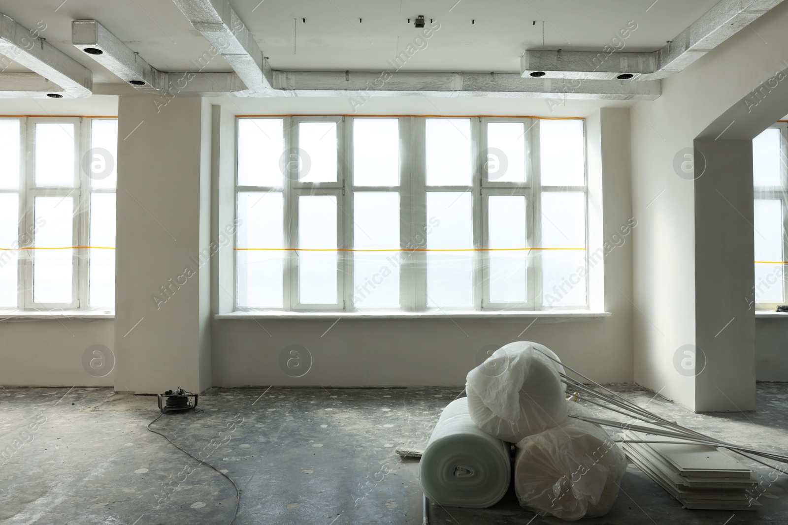 Photo of Polyethylene foam rolls on floor near windows in room