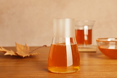 Glass jar with tasty honey on wooden table