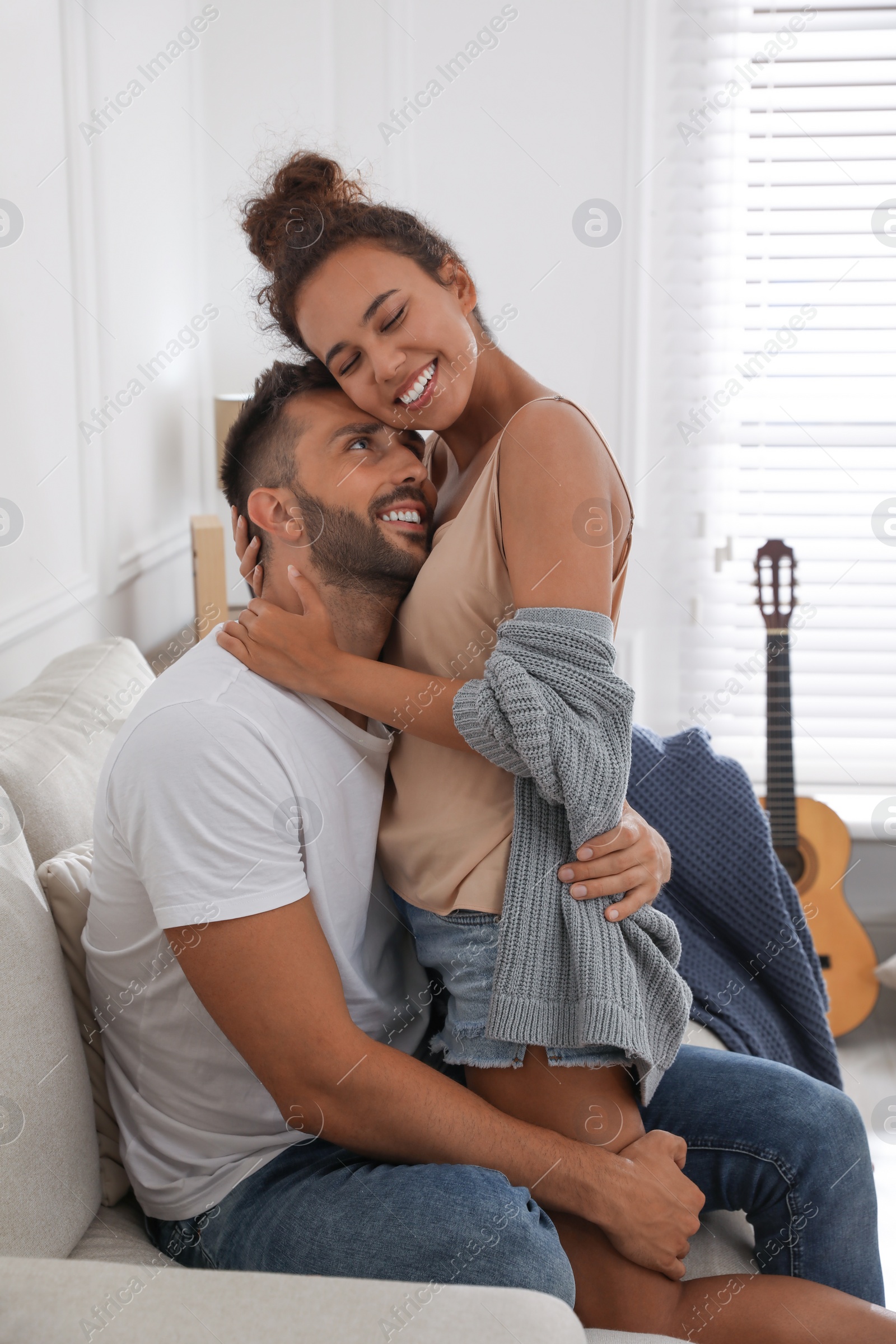 Photo of Lovely couple enjoying each other on sofa at home