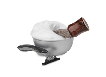 Shaving brush, bowl of foam and razor on white background