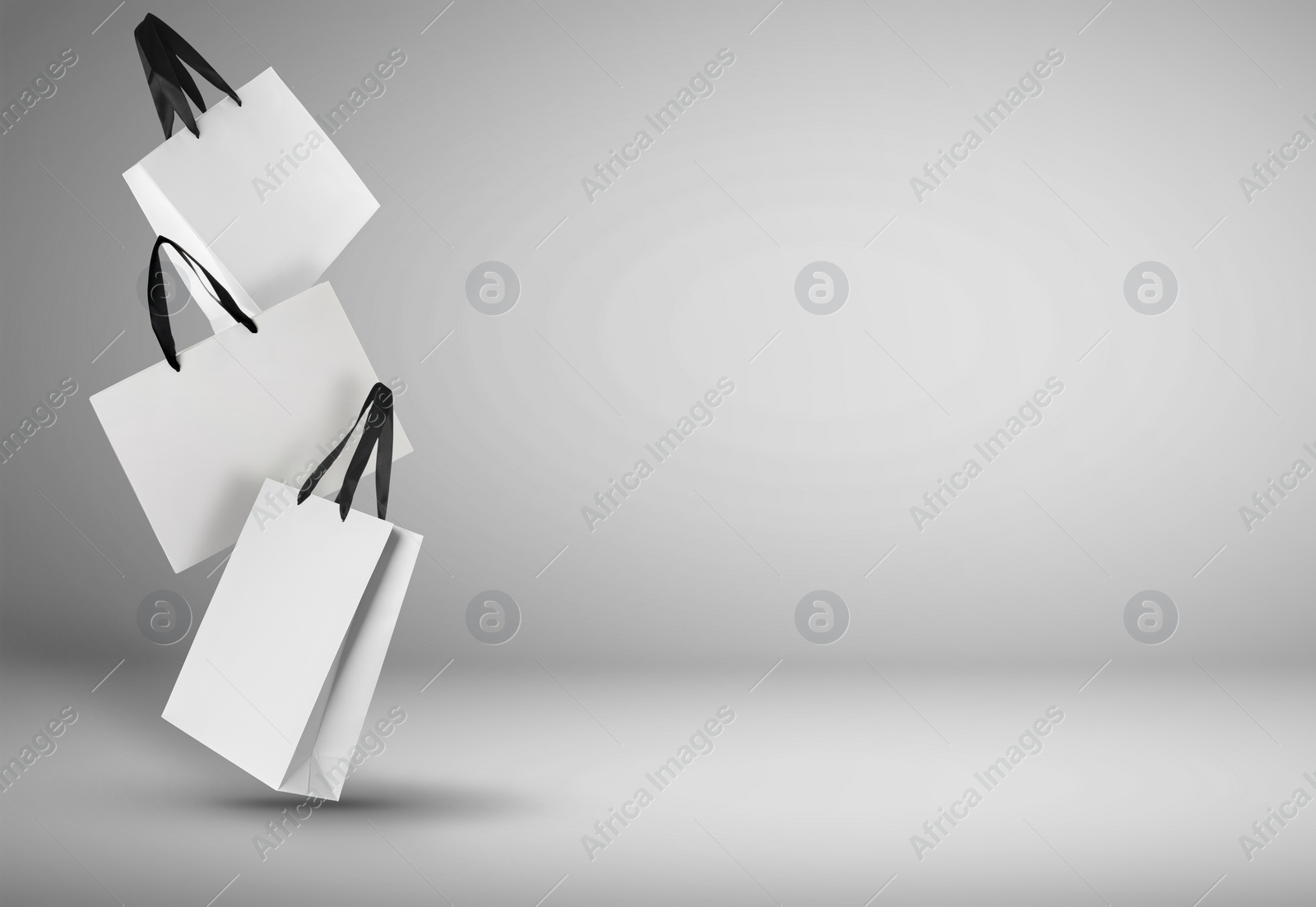 Image of Hot sale. White shopping bags in air on light gradient background, space for text