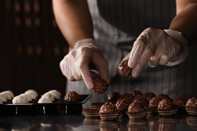 Photo of Woman packing delicious candies at production line, closeup