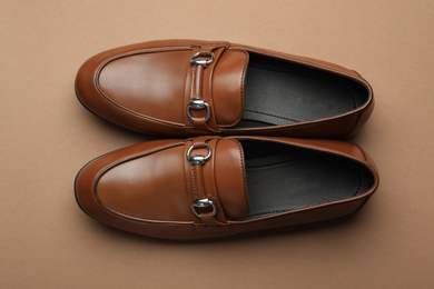 Photo of Pair of stylish male shoes on brown background, top view