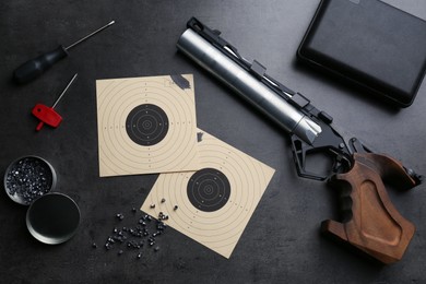 Flat lay composition with sport pistol on black table. Professional gun