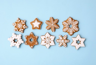 Photo of Christmas snowflake shaped gingerbread cookies on light blue background, flat lay