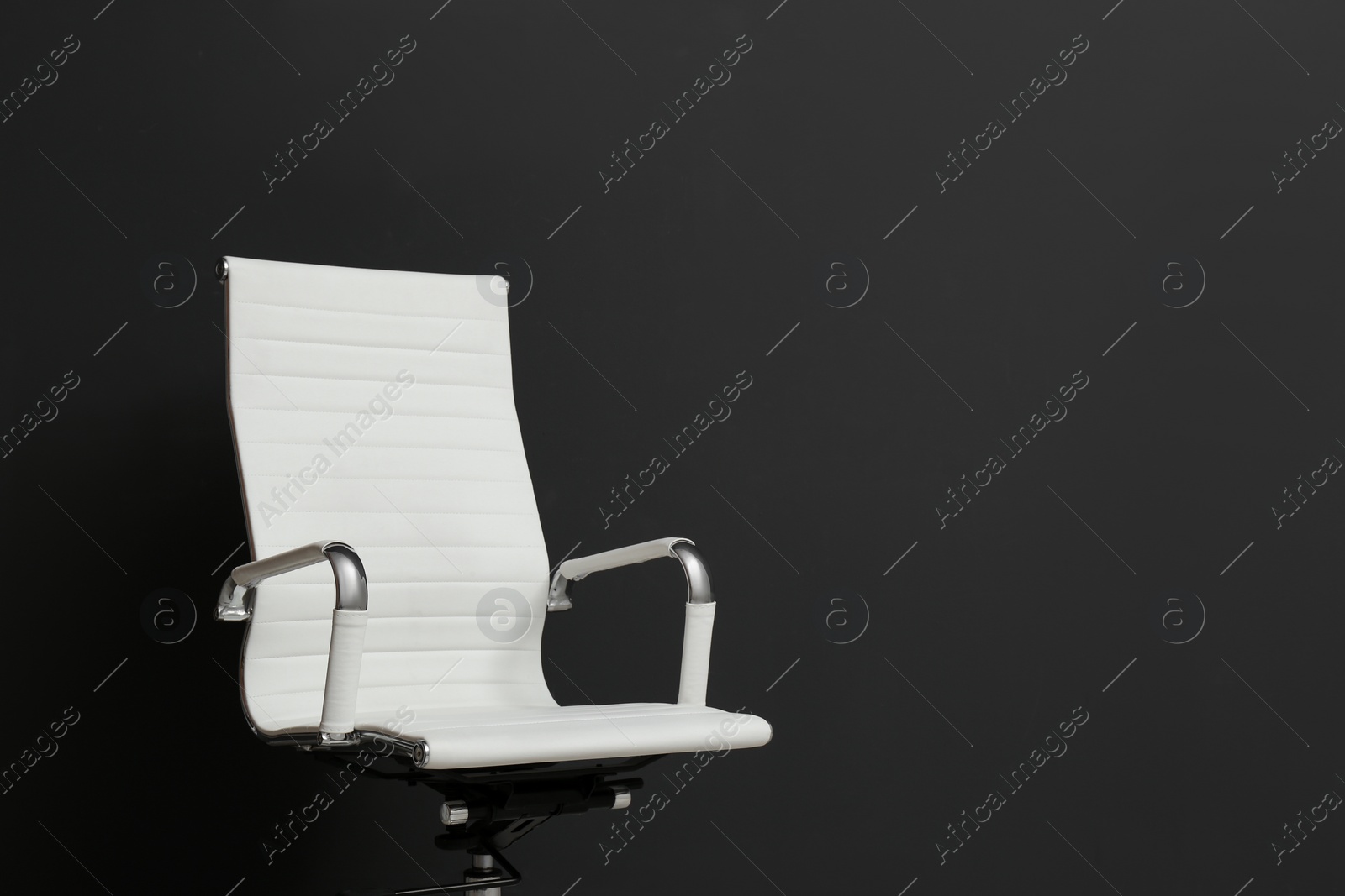 Photo of Comfortable office chair on black background. Space for text