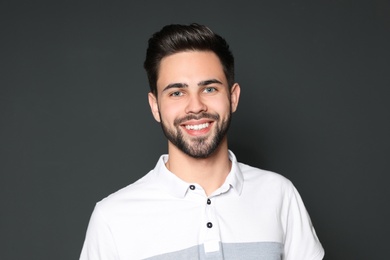 Photo of Portrait of handsome smiling man on grey background