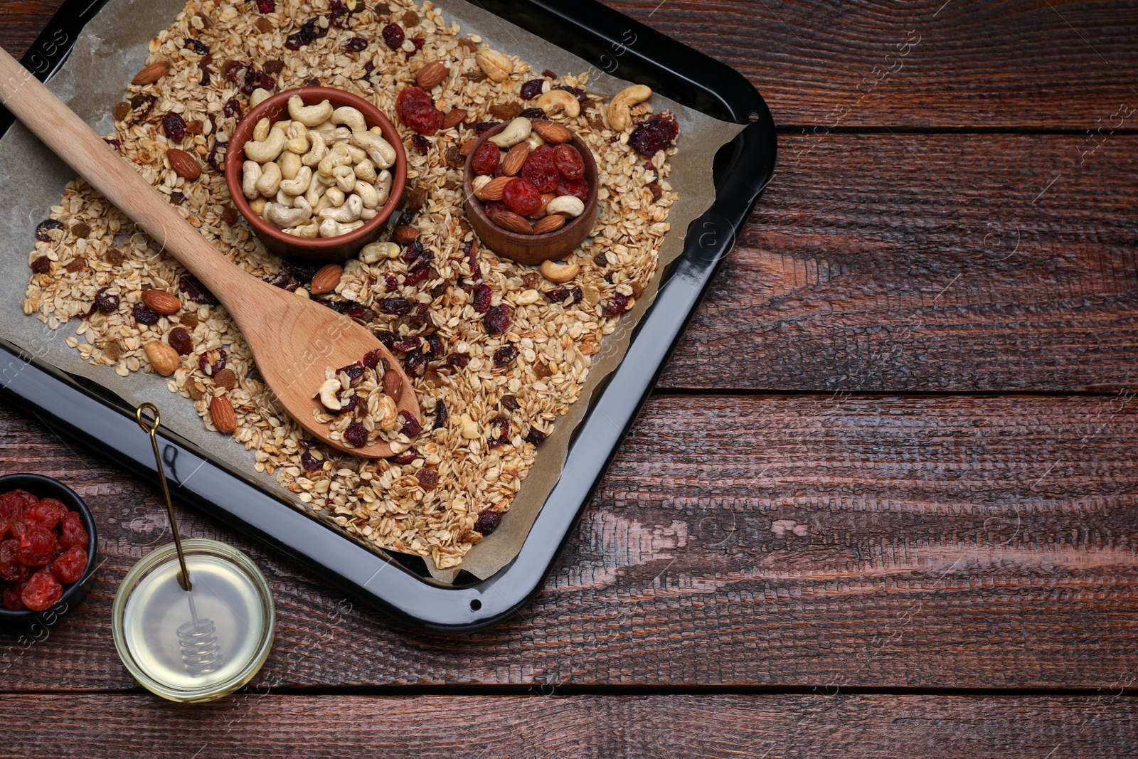 Photo of Tray with tasty granola, nuts and dry fruits on wooden table, flat lay. Space for text