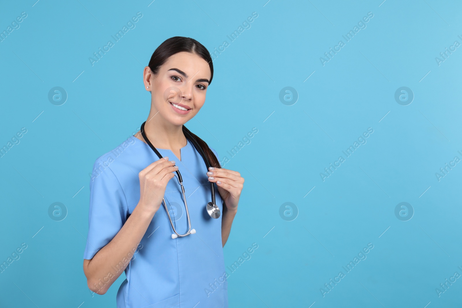 Photo of Portrait of medical assistant with stethoscope on color background. Space for text