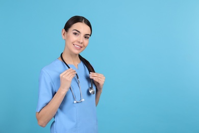 Portrait of medical assistant with stethoscope on color background. Space for text