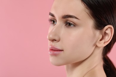 Photo of Beautiful young woman with healthy skin on pink background, closeup. Space for text