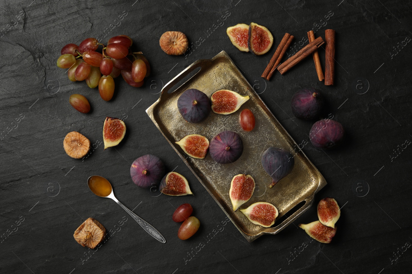 Photo of Flat lay composition with ripe figs on black slate table