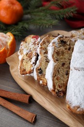 Traditional Christmas Stollen with icing sugar on wooden table, closeup