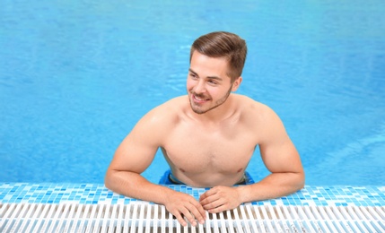 Handsome young man in swimming pool with refreshing water