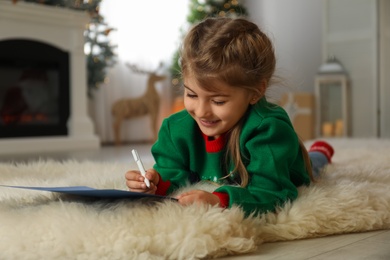 Cute child writing letter to Santa Claus at home. Christmas tradition