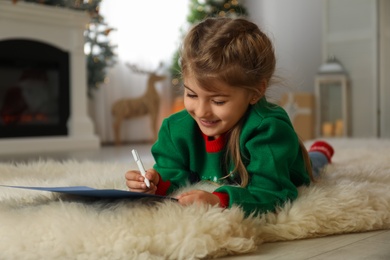 Photo of Cute child writing letter to Santa Claus at home. Christmas tradition