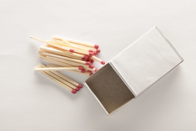 Photo of Cardboard box and matches on white background, top view. Space for design