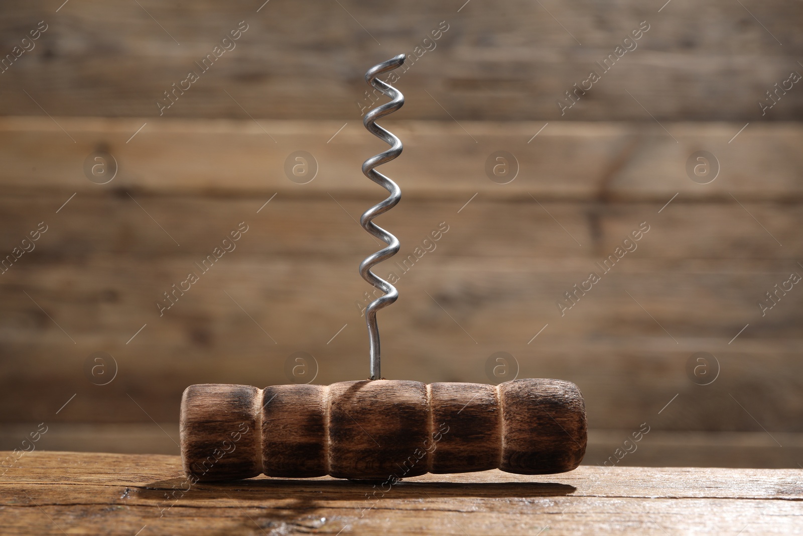 Photo of One corkscrew on wooden table, closeup view