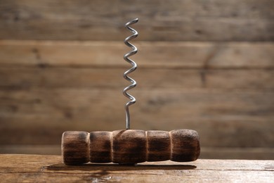 One corkscrew on wooden table, closeup view