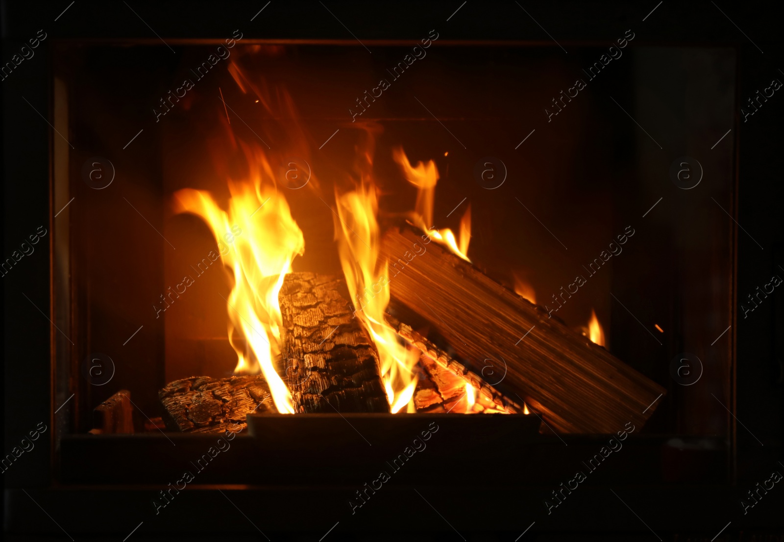 Photo of Fireplace with burning wood, closeup view. Winter vacation