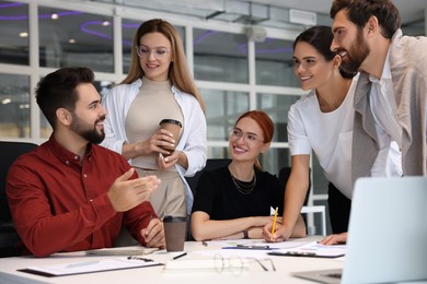 Photo of Team of employees working together in office