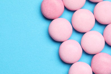 Photo of Pink bubble gums on blue background, flat lay. Space for text