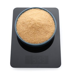 Modern kitchen scale with bowl of brown sugar isolated on white