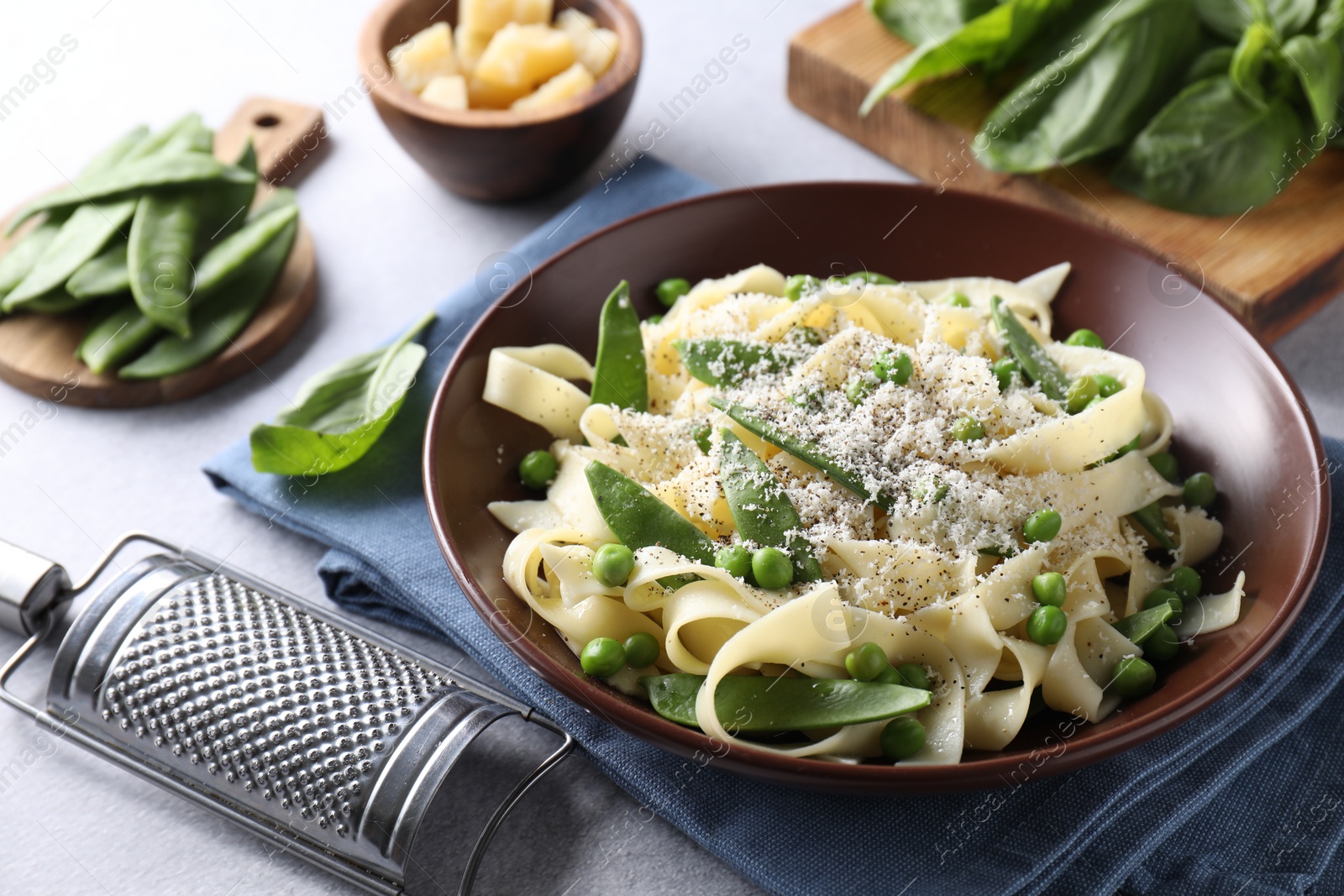 Photo of Delicious pasta with green peas on grey table, closeup