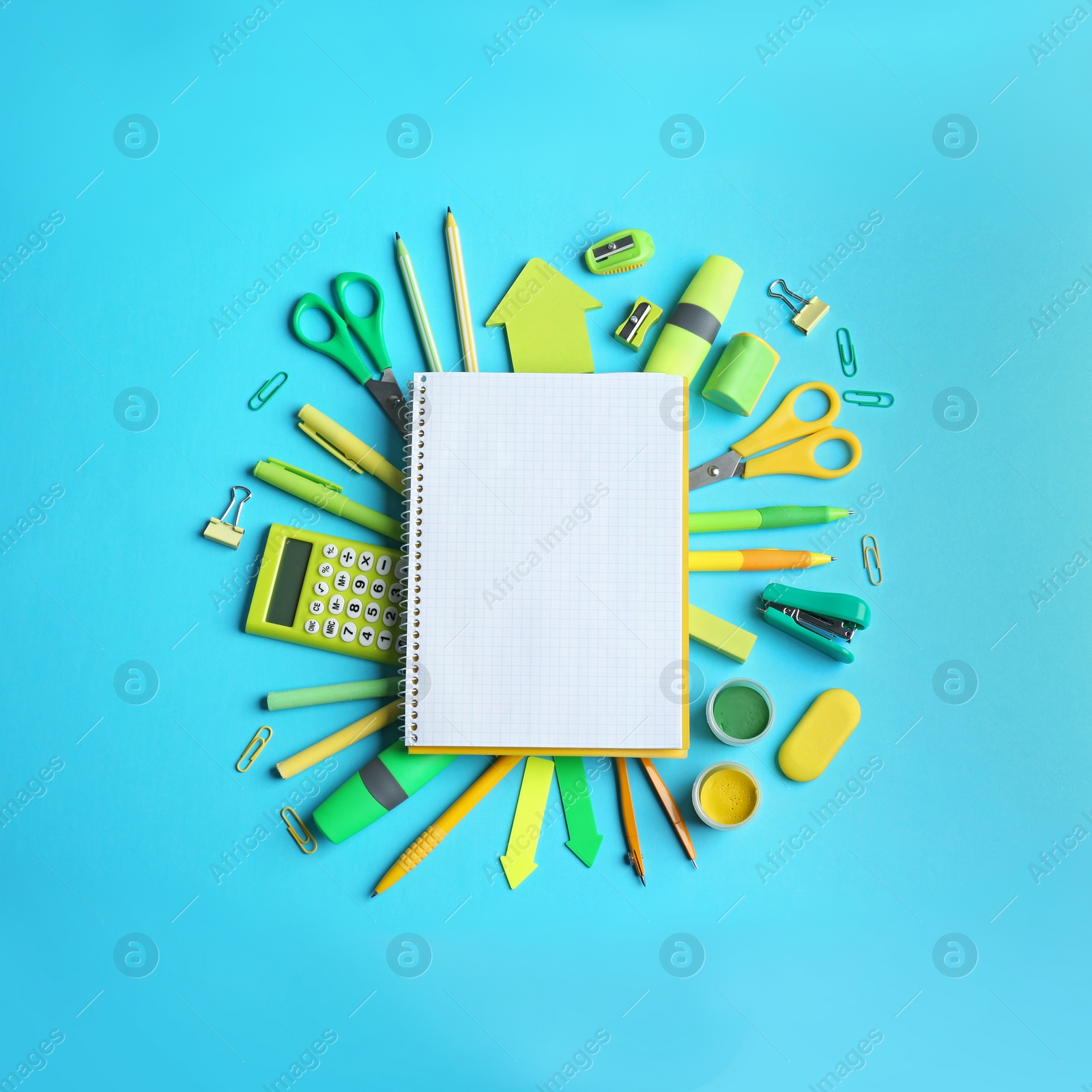 Photo of Different school stationery and open notebook on blue background, flat lay. Space for text