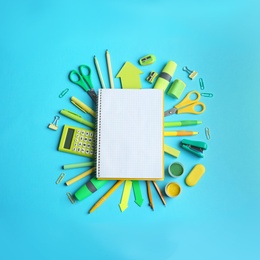 Photo of Different school stationery and open notebook on blue background, flat lay. Space for text