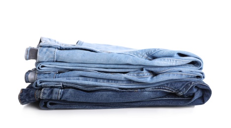 Photo of Stack of stylish jeans on white background