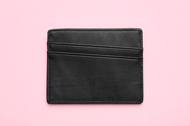 Empty leather card holder on pink background, top view