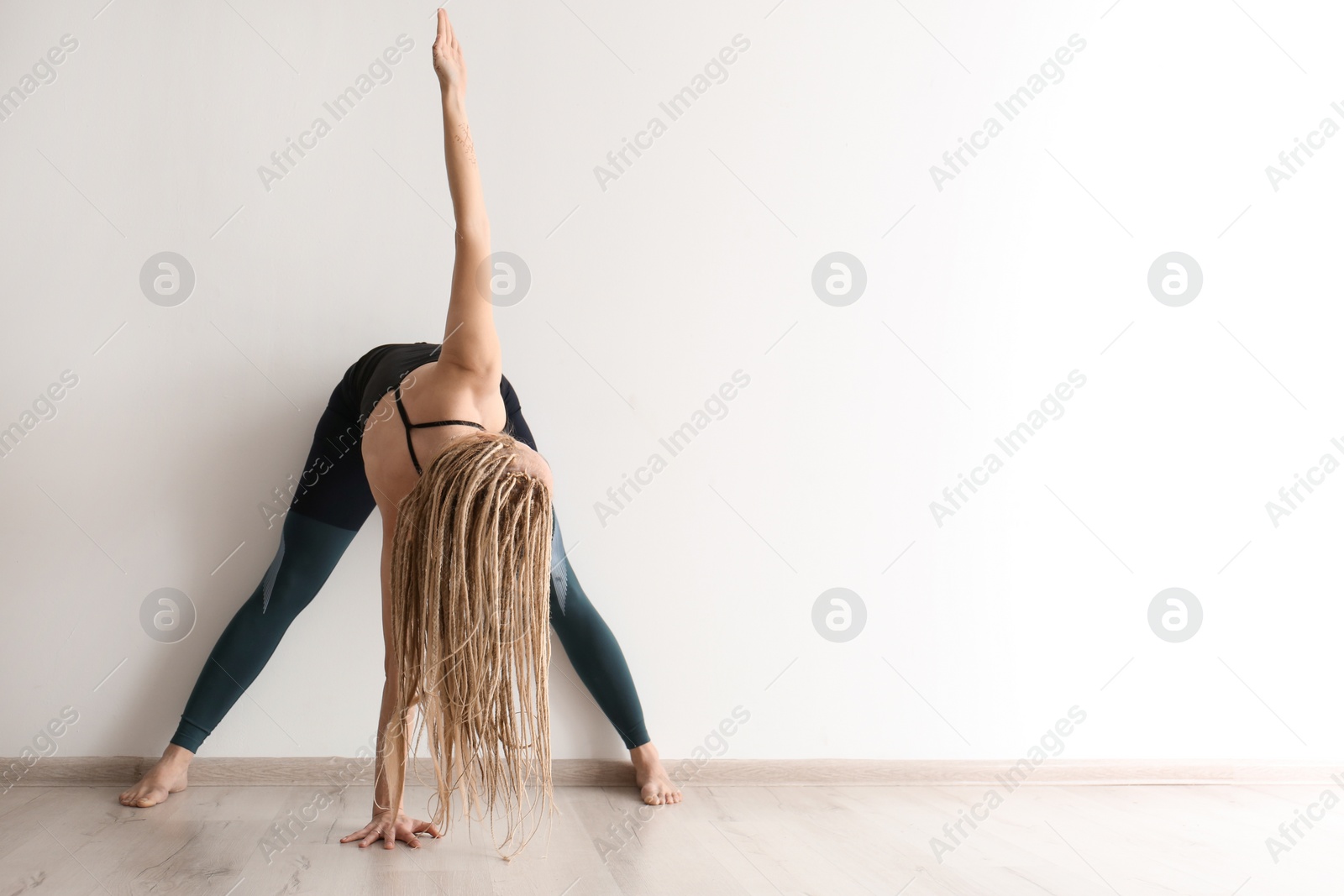 Photo of Young woman practicing yoga indoors